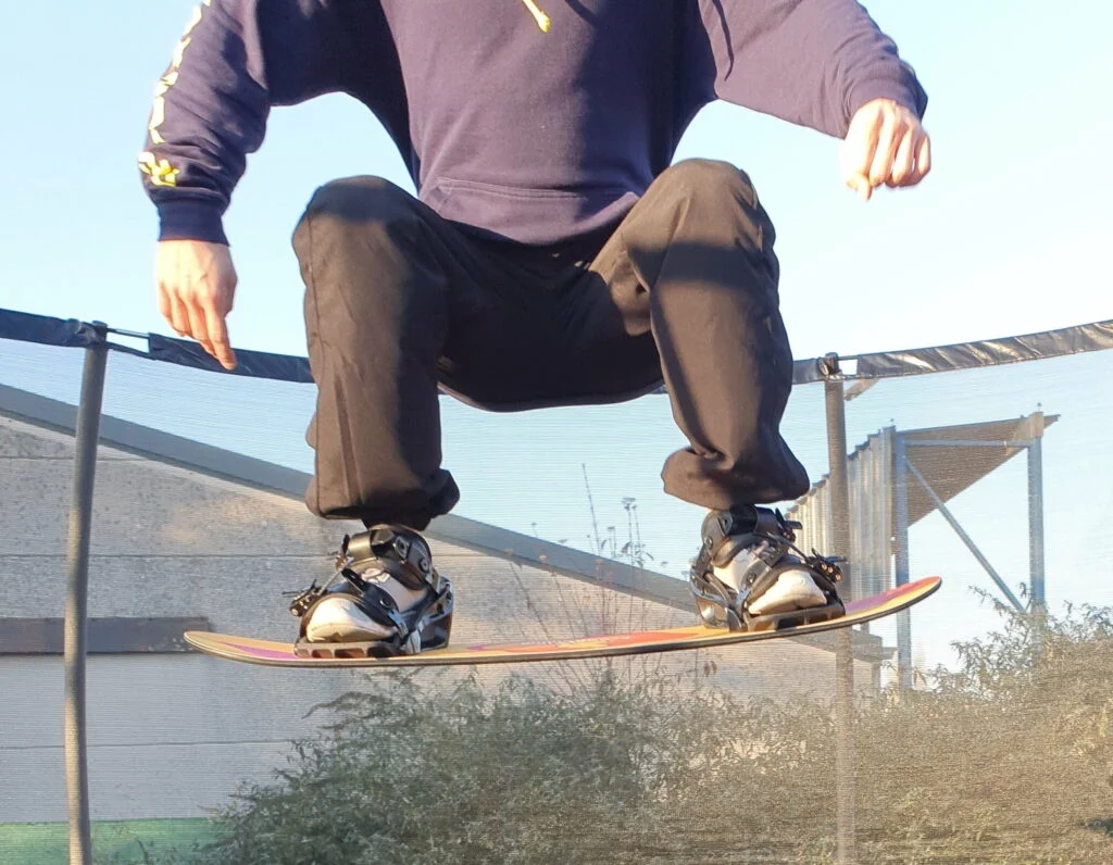Afbeelding van Freestyle Snowboard training, met een Trampoline Board, waarbij je een Grab gaat leren
